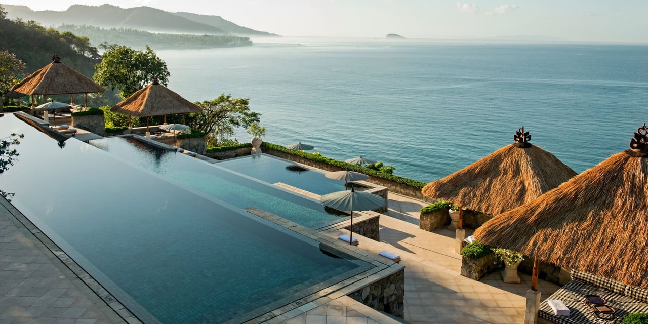 A cliffside infinity pool above the sea at first light
